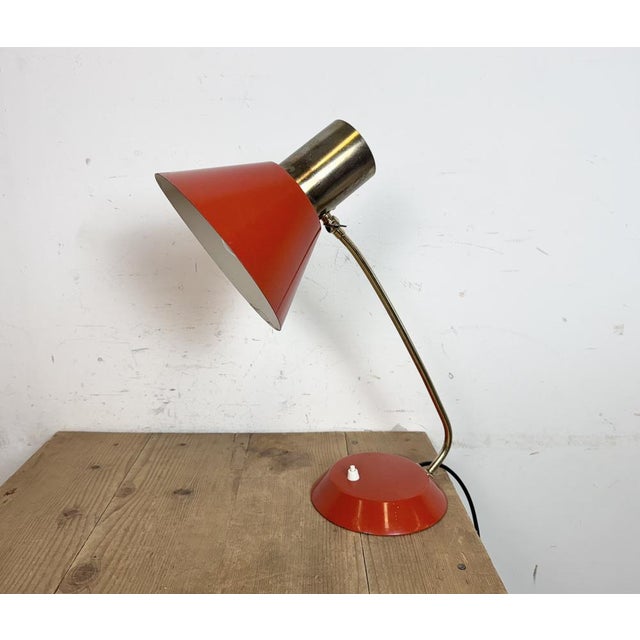 This adjustable table lamp was produced in former Czechoslovakis during the 1970s. It features an aluminium lampshade, a...