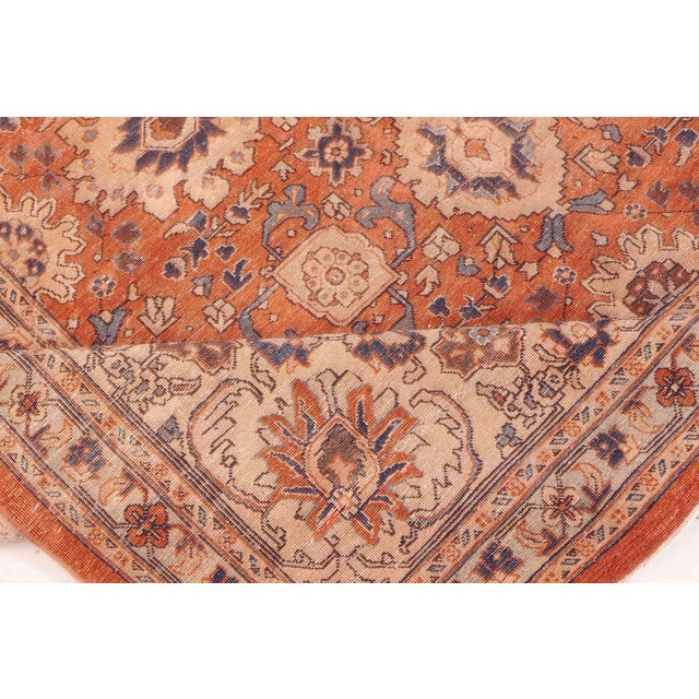 An early 20th century Persian Tabriz carpet, the persimmon field with flowerheads interspersed between rows of staggered...