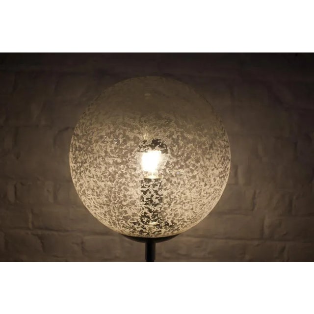 Tulip base in chromed steel tulip base, surmounted by a murano glass globe traveled by many inclusions. Kamar editor,...