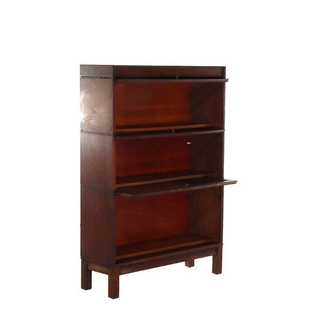 An antique American Arts and Crafts period three-stack barrister bookcase, crafted from quarter-sawn oak, dating to the...
