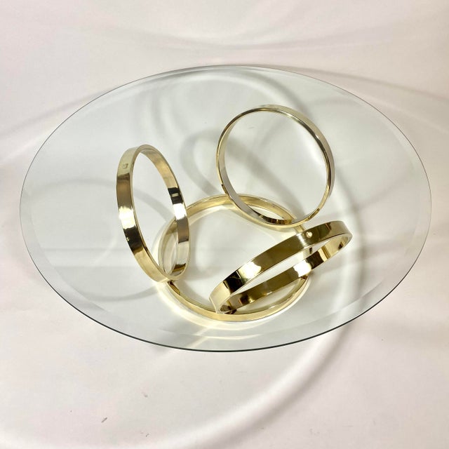 Mid century modern multi brass ring coffee table. Beveled glass top is included. Table does not have a sealer, brass plate...