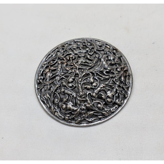 1970s round domed silvertone filigree foliate design brooch with security clasp. Marked "NAPIER©" on the bottom back of...