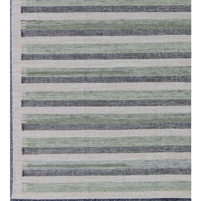 This modern Scandinavian flat-weave patterned rug is inspired by the work of Swedish textile designers of the early to...