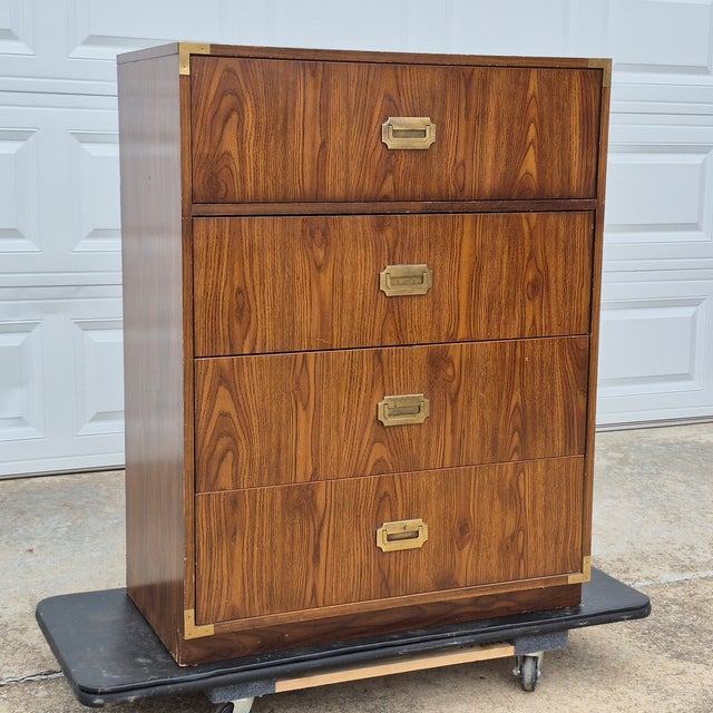 This is a vintage campaign style 4-drawer dresser made of a mix of wood and engineered wood clad in wood-tone laminate....