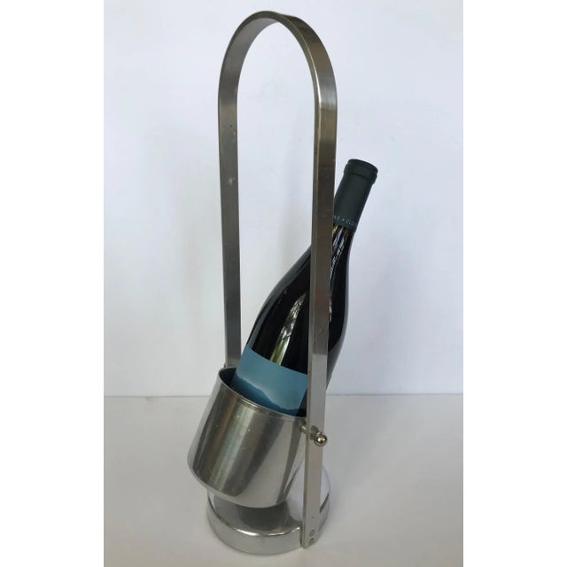 Vintage mid-century modern aluminum wine caddy. Wine holder has a round bucket hinged to a tall frame and round base. A...