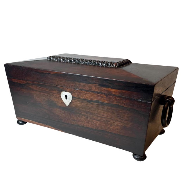 A beautiful Irish 19th century rosewood tea caddy has its original glass and all of its interior. A sarcophagus design...