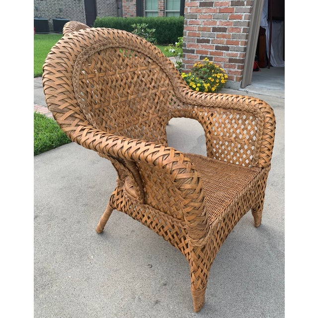 Offering a delightful pair of well made vintage club chairs made of wicker with a rattan strip overlay in an interesting...