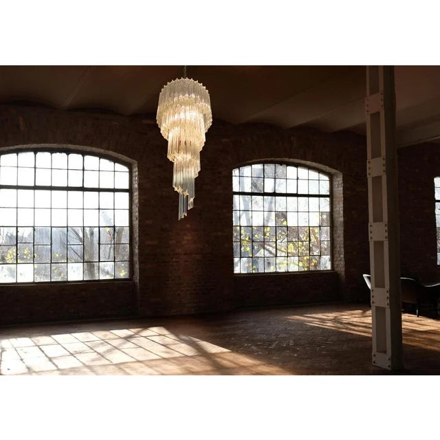 Fantastic pair of chandeliers with 86 Murano crystal transparent prisms in a nickel metal frame. The shape of this...