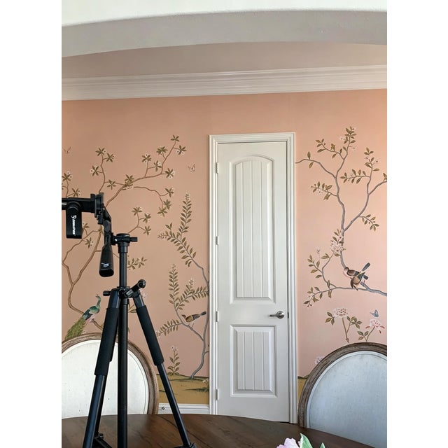 This hand painted Chinoiserie-style wallpaper mural features delicate botanical branches, blooming flowers, and charming...
