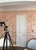 This hand painted Chinoiserie-style wallpaper mural features delicate botanical branches, blooming flowers, and charming...