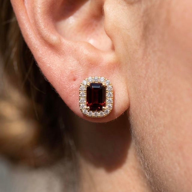 Showcase rich, luxurious color with these exquisite halo stud earrings, centered around an emerald-cut natural gemstone...