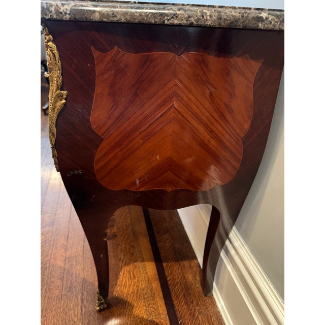 A refined pair of French Louis XV–style marble-top nightstands or bedside chests, beautifully crafted with rich book...