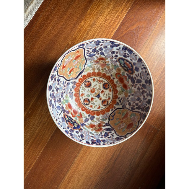 This piece features a vibrant "brocaded" floral design with deep cobalt blues, rusty iron-reds, and delicate gold gilt...