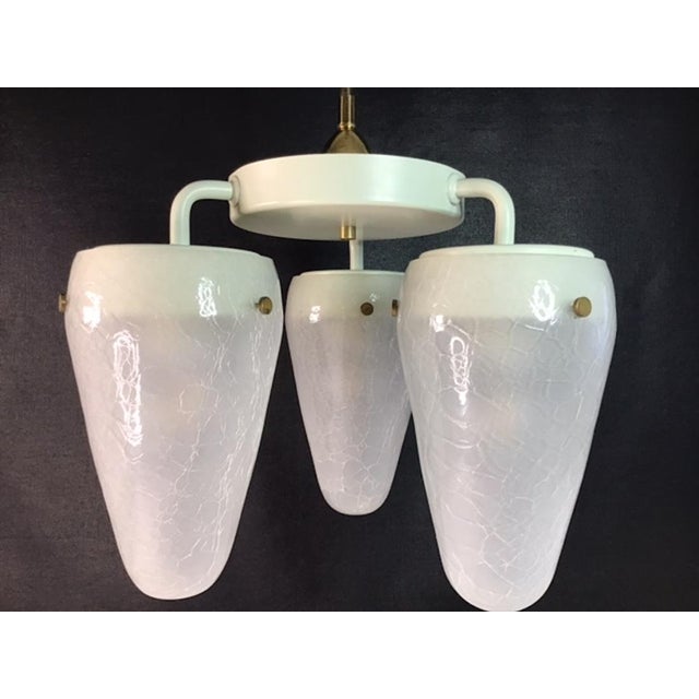 A luxurious plafond lamp that creates a soft, ambient light through its brass-supported fabric shade. The lamp is designed...