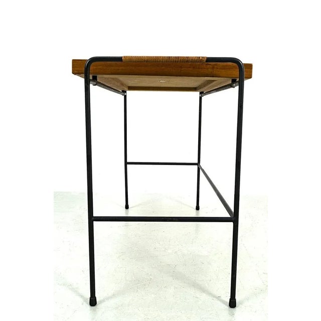 This straight and neat side table with a teak top and a wire metal frame. There is a faded mark on the bottom of the board...
