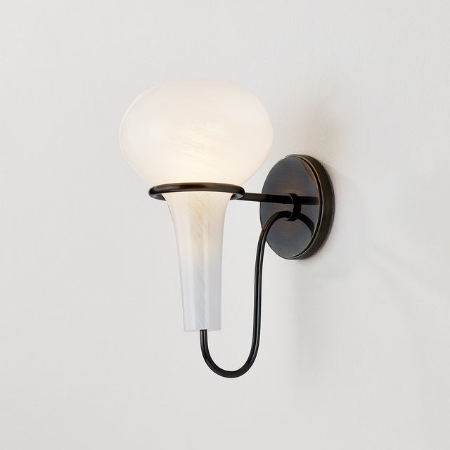 A delicate metal framework supports the upside-down, pear-shaped shade of the Adams Corner sconce. Adding a surprising...