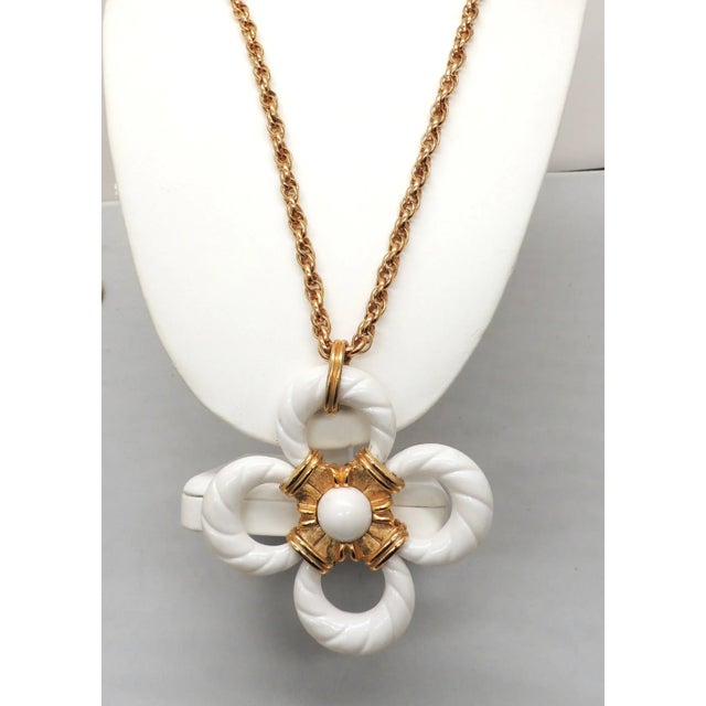 This is part of Chairish’s Costume Jewelry assortment. 1970s goldtone and white resin pendant necklace with spring ring...