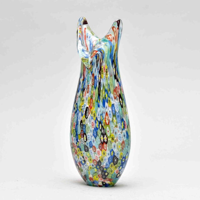 In the tradition of Murano glassmaking, this hand-blown vase is densely encrusted with multicolored millefiori cane slices...