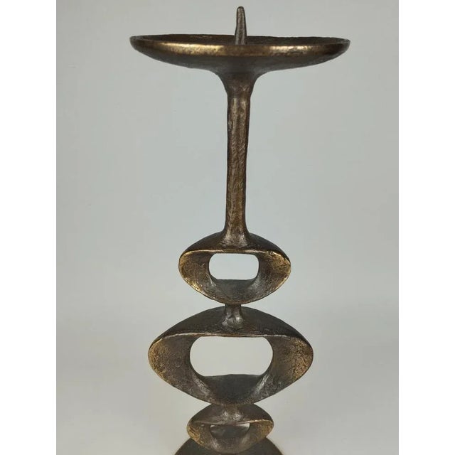 A really elegant sculptural candle stand made of bronze, which is probably intended for the ground than for the table...