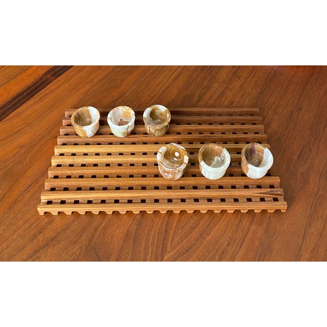 Carved from solid blocks of pure onyx stone, this set of six organic modern cups set atop the beautifully crafted display...