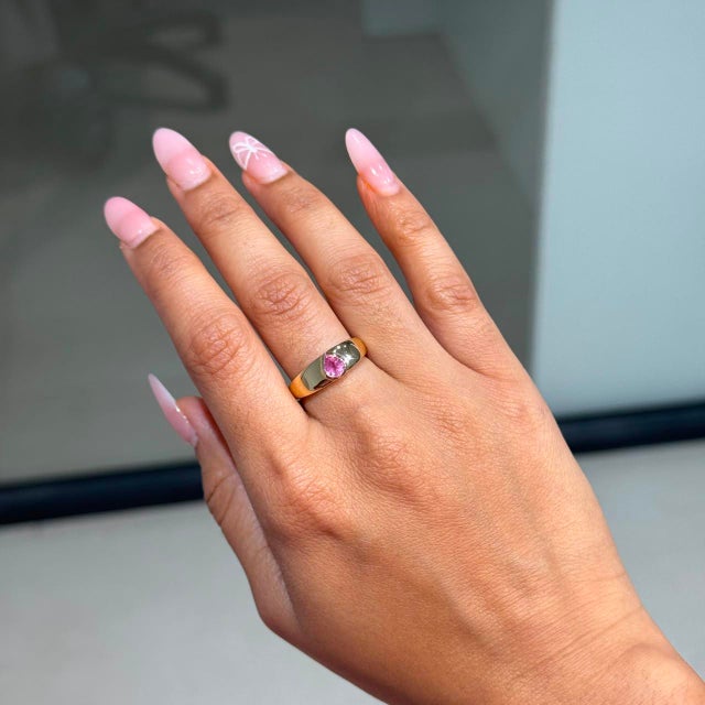 This Antique style signet ring showcases a 0.62 carat natural pear cut pink sapphire, set in 14K yellow gold. The sapphire...