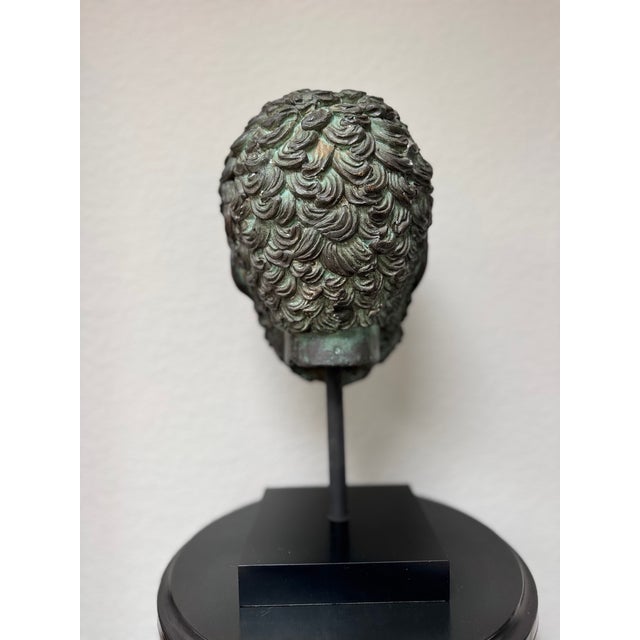 A striking Grand Tour-style head of Zeus, rendered with powerful classical features and a richly developed verdigris...