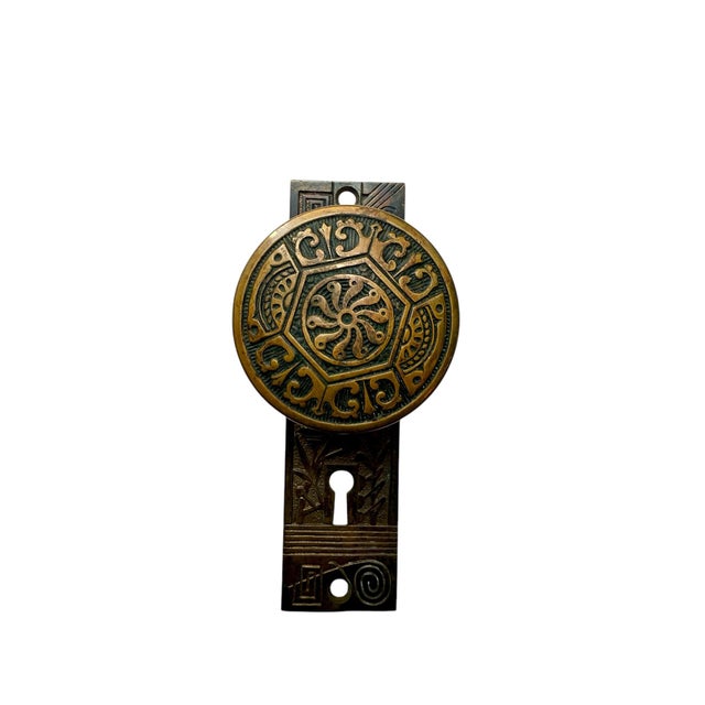 A pair of cast bronze door plates and door knobs in an Aesthetic Movement design made by Nashua Lock Co. circa 1886. The...