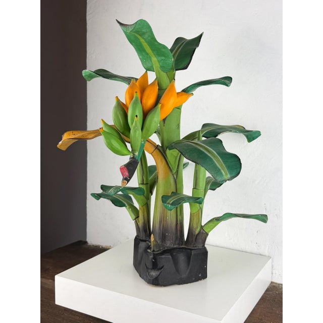 A mid-century hand-carved wooden sculpture depicting a lush banana tree Crafted in South America, this vibrant folk art...