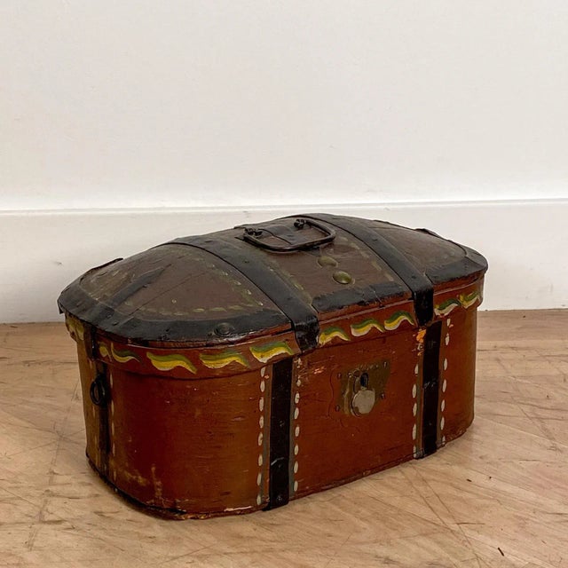 A 19th-century oval painted box, with a red painted inside, possibly German, painted later.