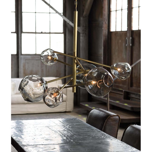 This chandelier’s hand-crafted glass shades combined with natural brass lend a distinct, artisan effect. Molten glass has...