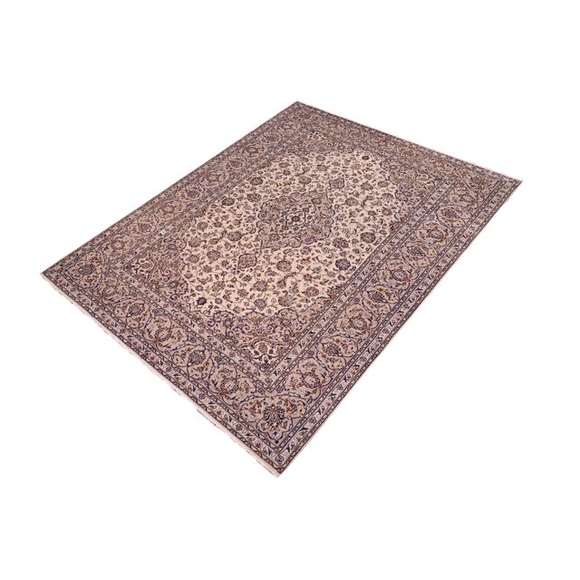 A beautiful hand-knotted wool rug measuring approximately 8'2" x 11'6". This elegant carpet features a soft ivory field...