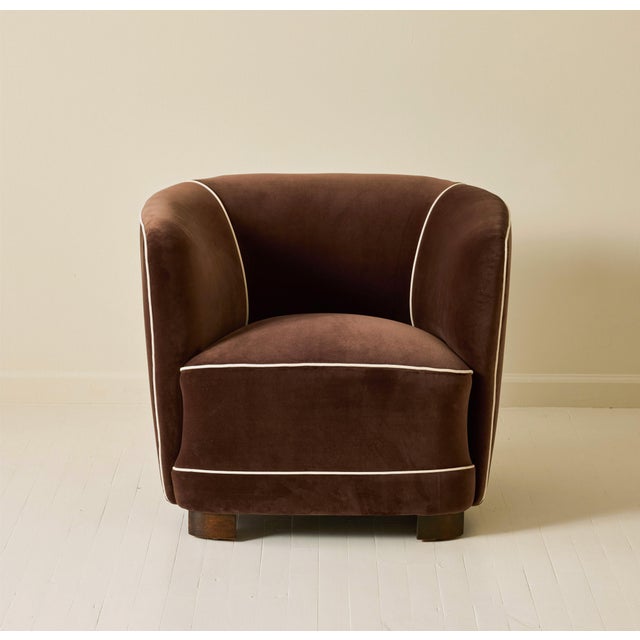 Danish Art Deco club chair upholstered in Dedar velvet with ivory piping. The chair features an enveloping barrel-form...
