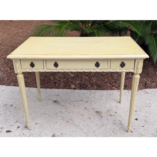 Distressed painted writing computer desk by Hooker Furniture. Pale yellow with carved detailed legs. The middle drawer...