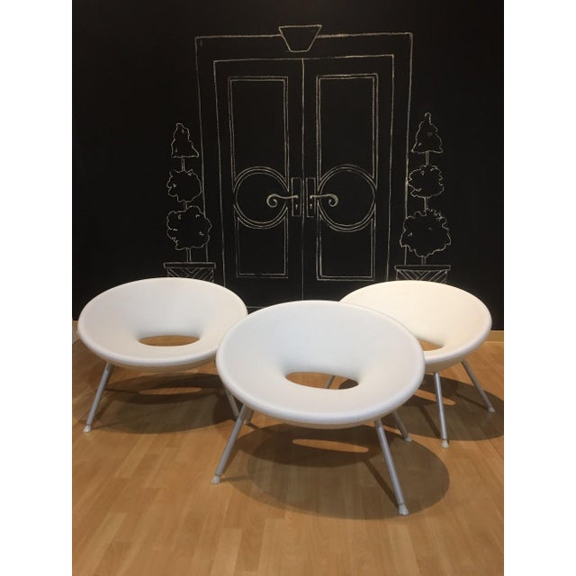 White plastic ploof, scoop chair made of plastic with aluminum legs. Use as a desk chair, accent chair or outdoors on the...