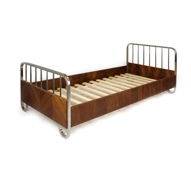 Elegant pair of single beds from the 1930s, combining chrome-plated steel frames with warm walnut veneer panels. The...