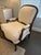 Offered is a classic style upholstered bergere chair. This piece features neutral off-white upholstery and sturdy stained...