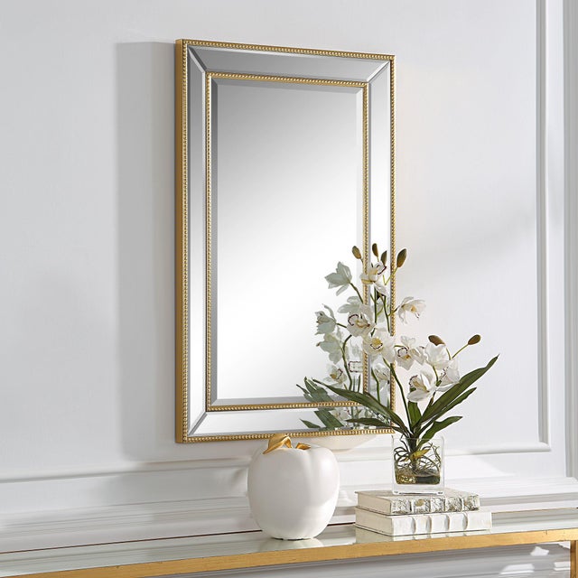 This elegant frame, made with beveled mirror, is accented with gold beading, outlining both the inner and outer frame. The...