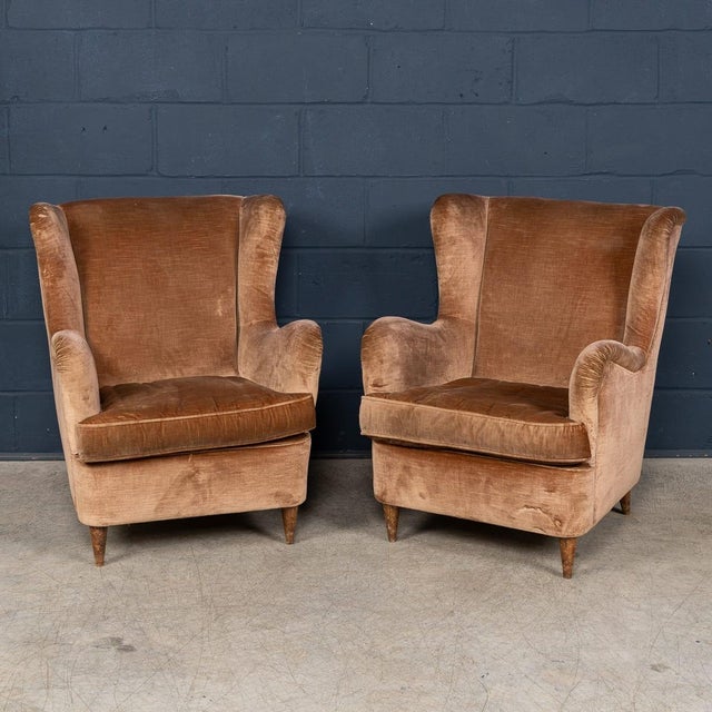 A stylish pair of Italian armchairs dating to the 1960s, upholstered in soft velvet. These chairs feature a classic...