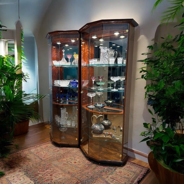 Offering a book-matched pair of vitrine display cabinets by Henredon. This 1992 set is quality-built in figured hardwood-...