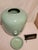 This vintage 1981 Jaru California Pottery ceramic vase features a smooth, glossy sage green or celadon glaze and an...