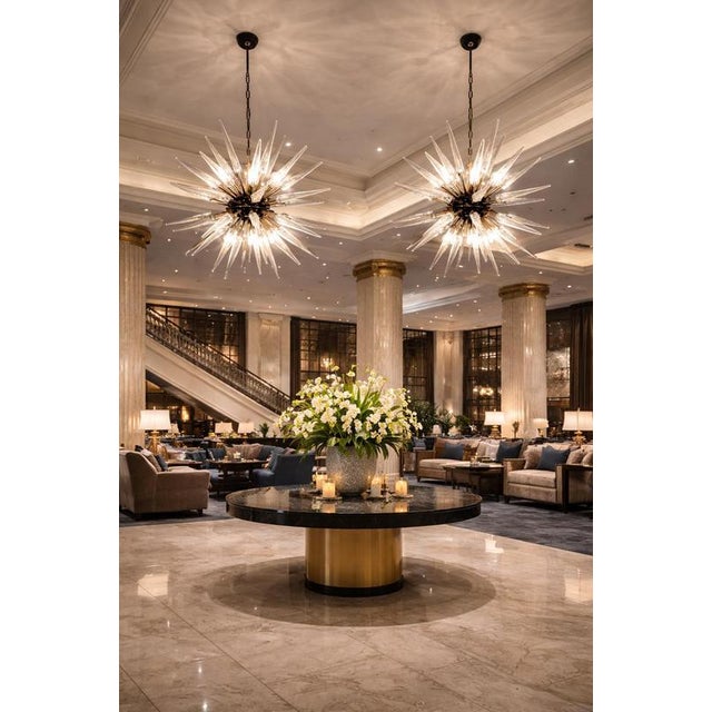 Pair of Italian Sputnik chandeliers in a black and brass metal, 51 unobtainable transparent glass tips. Murano blown glass...