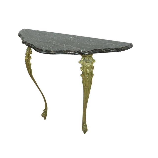 Classic wall console table in antique louis xvi baroque style; a brass console featuring ornate legs decorated with...