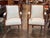 Pair of French Empire–style armchairs with curved backs, scroll arms, and carved wood frames. Upholstered seats and backs...