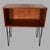 A compact and versatile mid-century teak open cabinet, raised on slender black metal hairpin legs for a clean,...