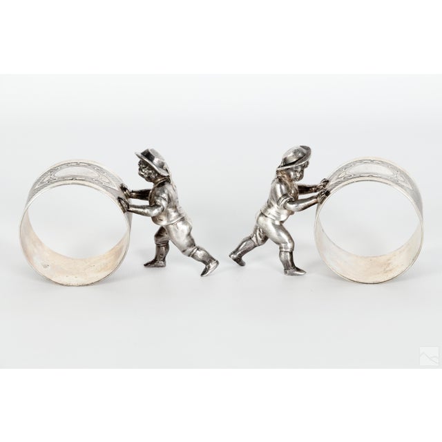 Set of two antique 19th Century German silverplate figural napkin rings. Each with a figure of rustic child wearing a hat,...