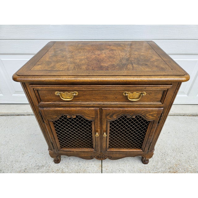 French style Baker Furniture nightstand with a banded burlwood veneer top. This piece features one drawer and a lower...