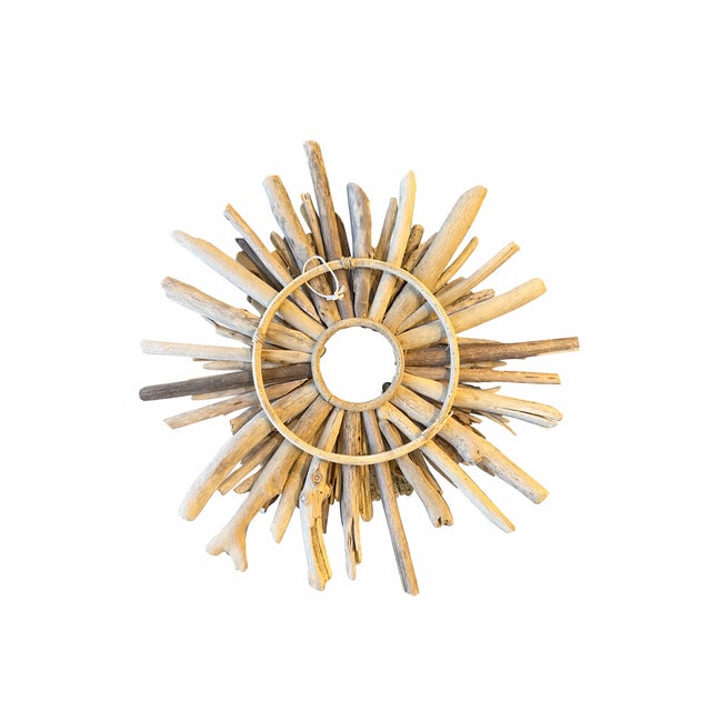 This handcrafted coastal sunburst mirror is created from natural driftwood branches arranged in a dramatic radial pattern...