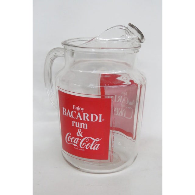 This gorgeous Beverage Pitcher is made of clear glass. This striking pitcher has a classic vintage design from the 1970s;...