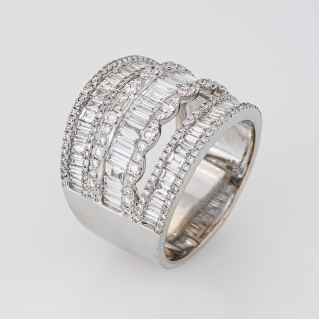 Stylish wide diamond band crafted in 18 karat white gold (circa 1970s). Mixed cut round brilliant and baguette diamonds...