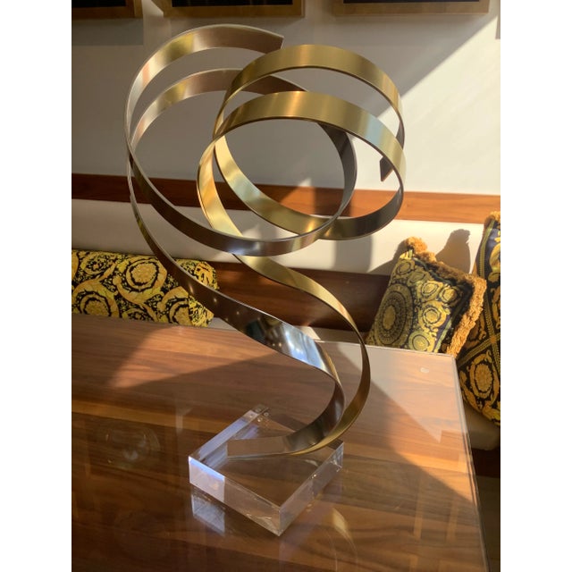 Mid century modern abstract Dan Murphy (American) anodized aluminum ribbon sculpture on Lucite base. Two gold and silver...